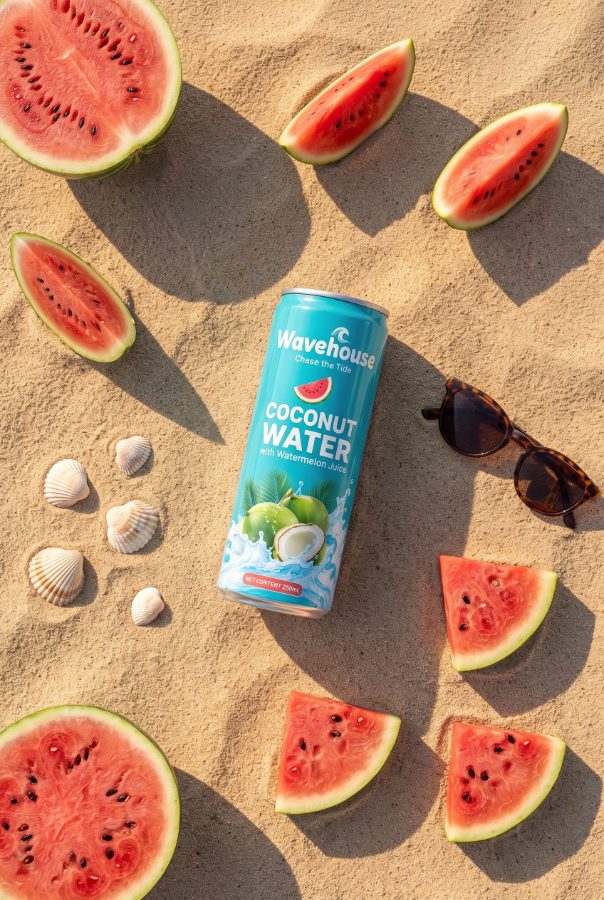 Wavehouse coconut water flat lay on sand — beverage marketing visual